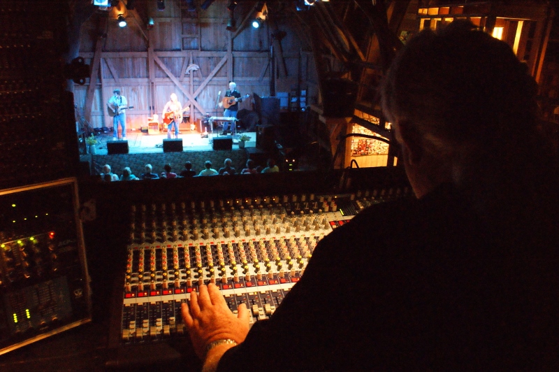 Steve Ellmann in his familiar perch at the soundboard at Fishstock. Ellmann takes over management of the concerts from his brother Dave this summer. Photo by Suzi Hass.