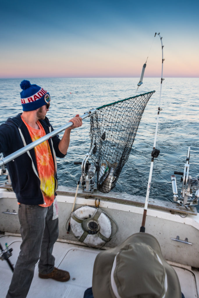 First Mate Cammeron McCluggage nets a fish on a charter trip. Photo by Len Villano.