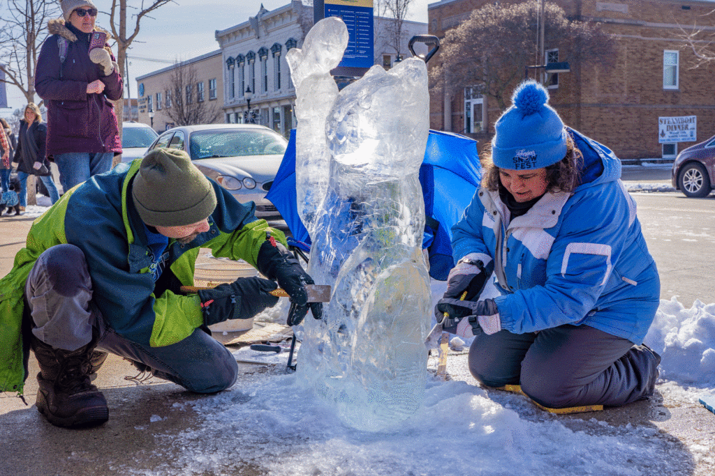Garret Wendlandt, Sturgeon Bay native and carver of 13 years, attaches a fish to the cat sculpture he has been woking on with Christy Dunsmoor, Green Bay ice carver of 15 years. Photo by Rachel Lukas.
